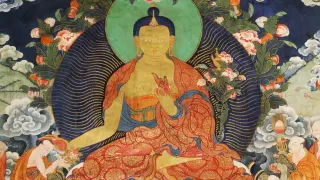 Siedzący Budda w czerwonych szatach, otoczony kwiatami i chmurami. Wokół niego wierni oddają mu cześć. Sat Nam.